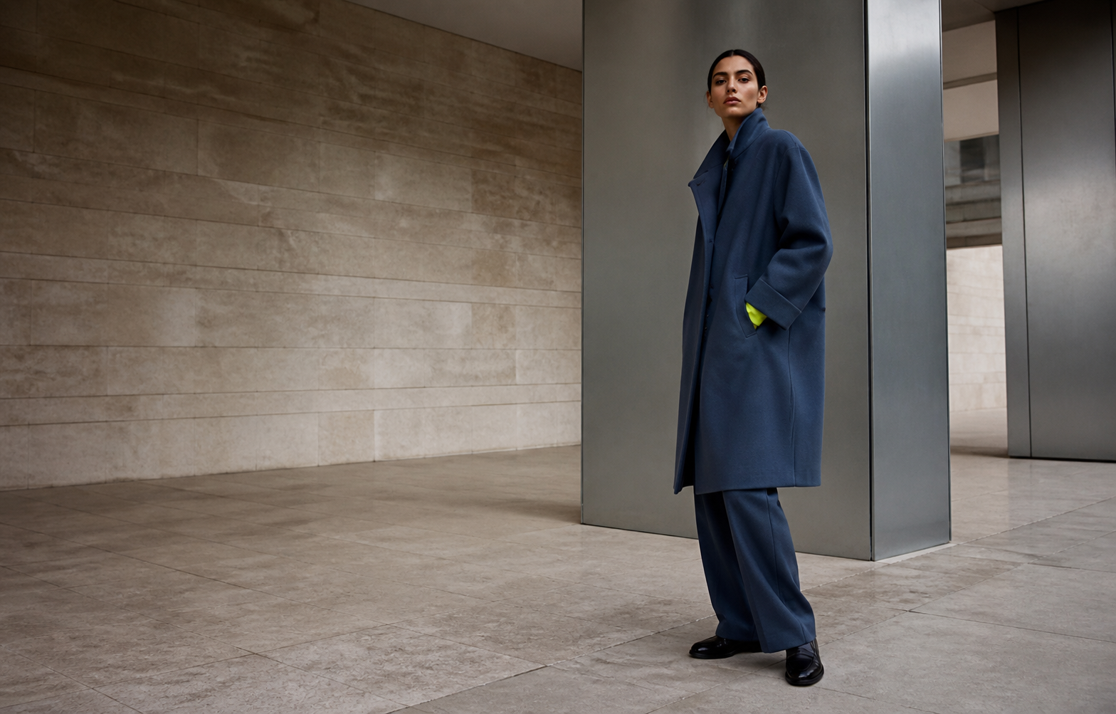 Model wearing a navy coat from the Clothers Transit collection